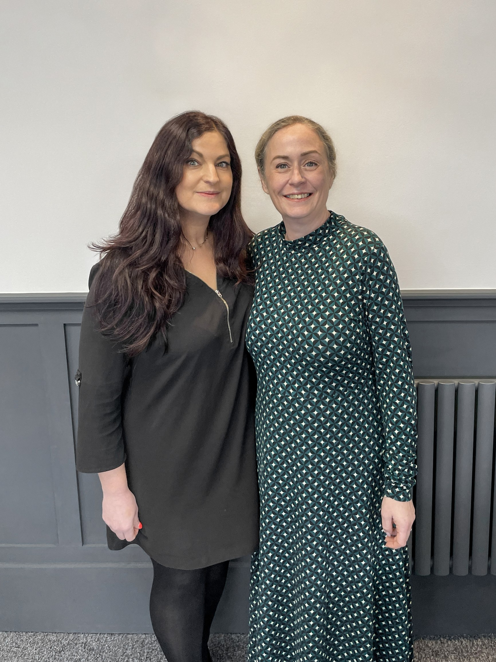 A photo of two women- the owners of the business, standing next to each other and posing for a photo.
